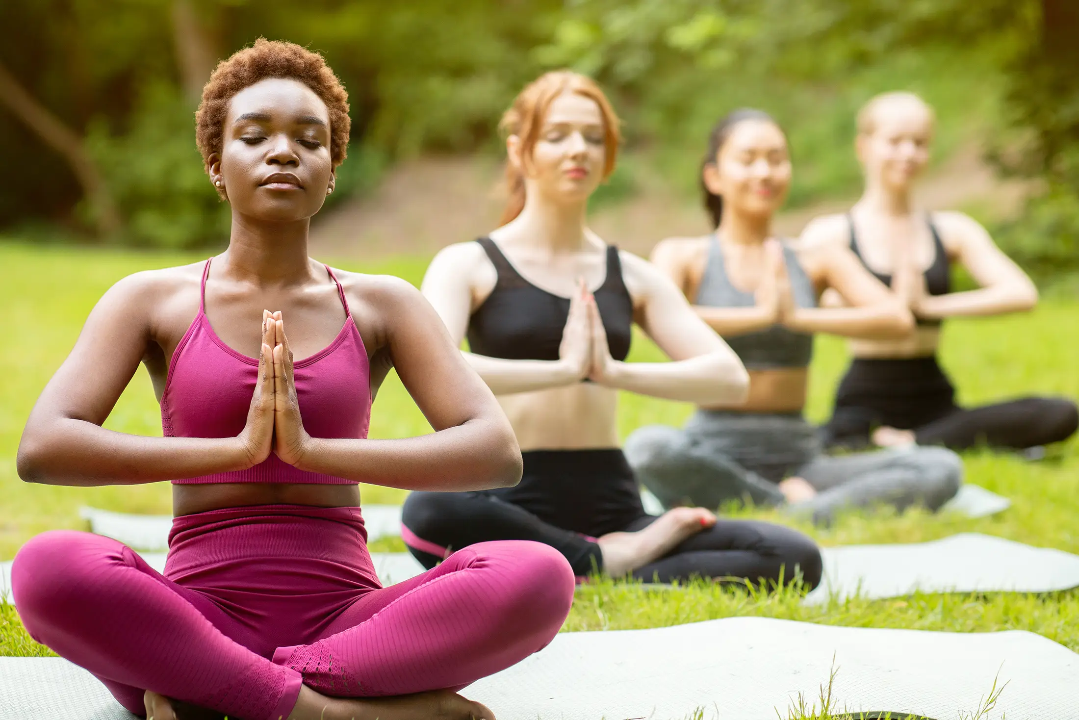 women exercising doing yoga outside 